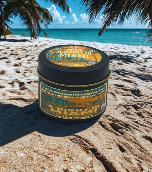 Twin Palms A Night In Miami candle tin on a sandy beach with palm trees and ocean in the background