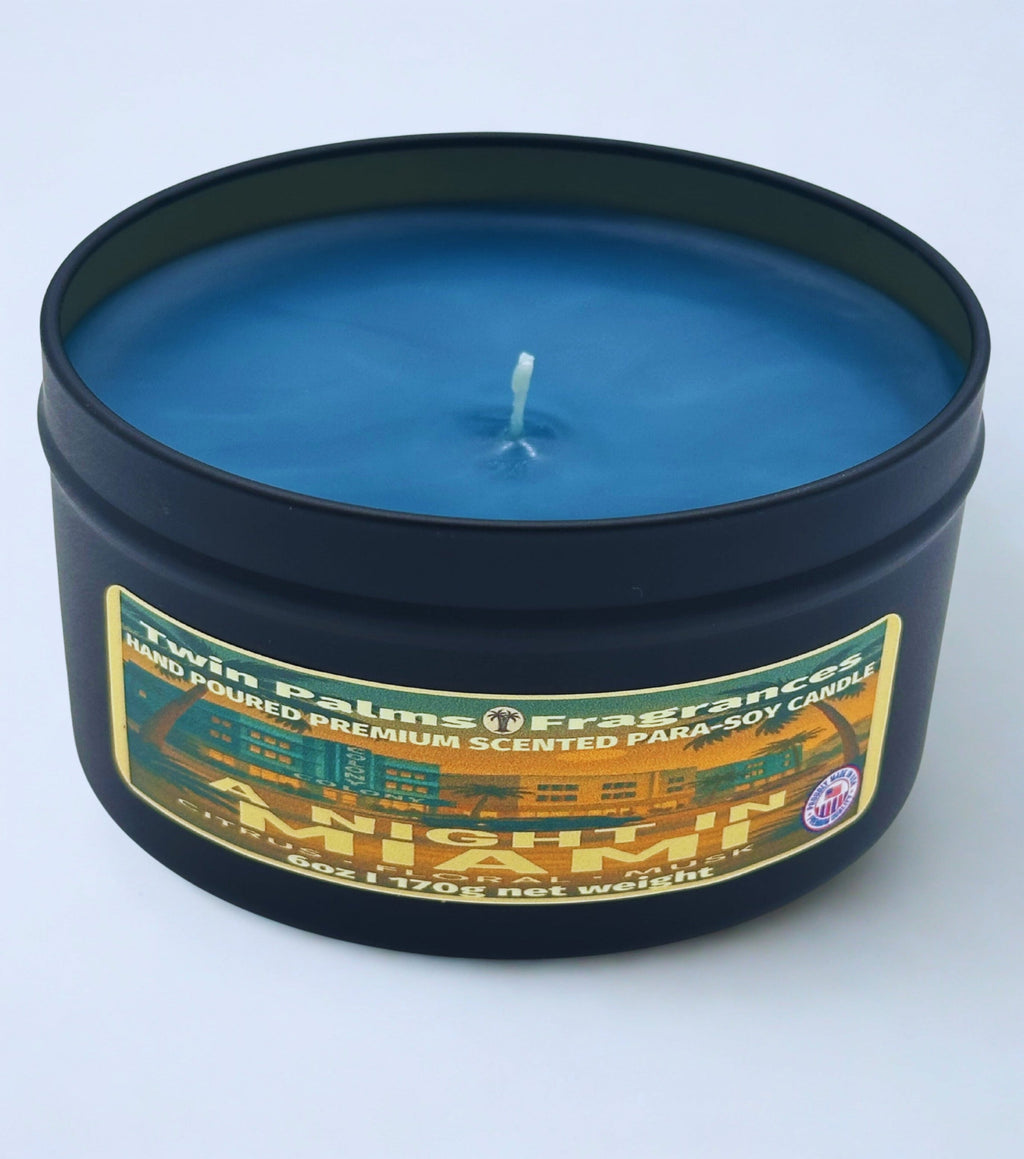 Blue candle in a black tin with 'Twin Palms Fragrances' label on a light blue background