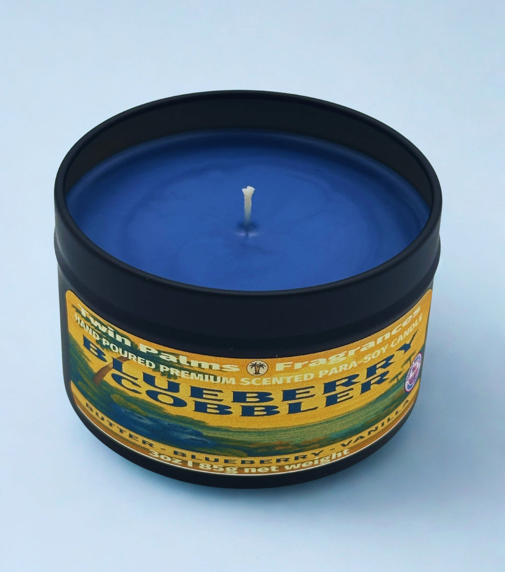 Blueberry Cobbler candle in a tin with a label on a light blue background