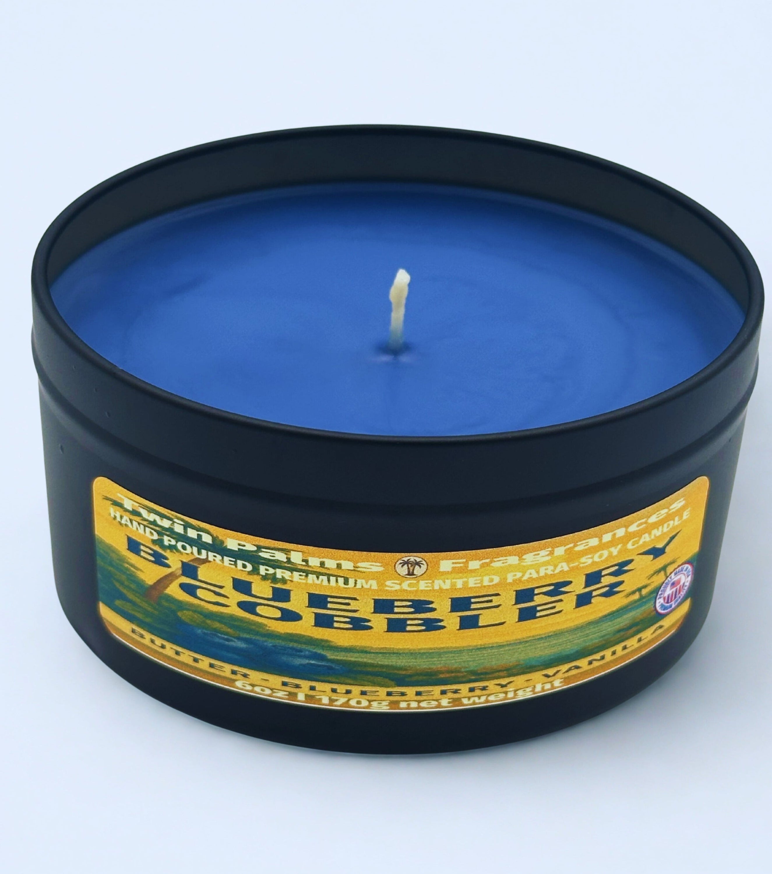 Blueberry Cobbler candle in a tin with a label on a light blue background