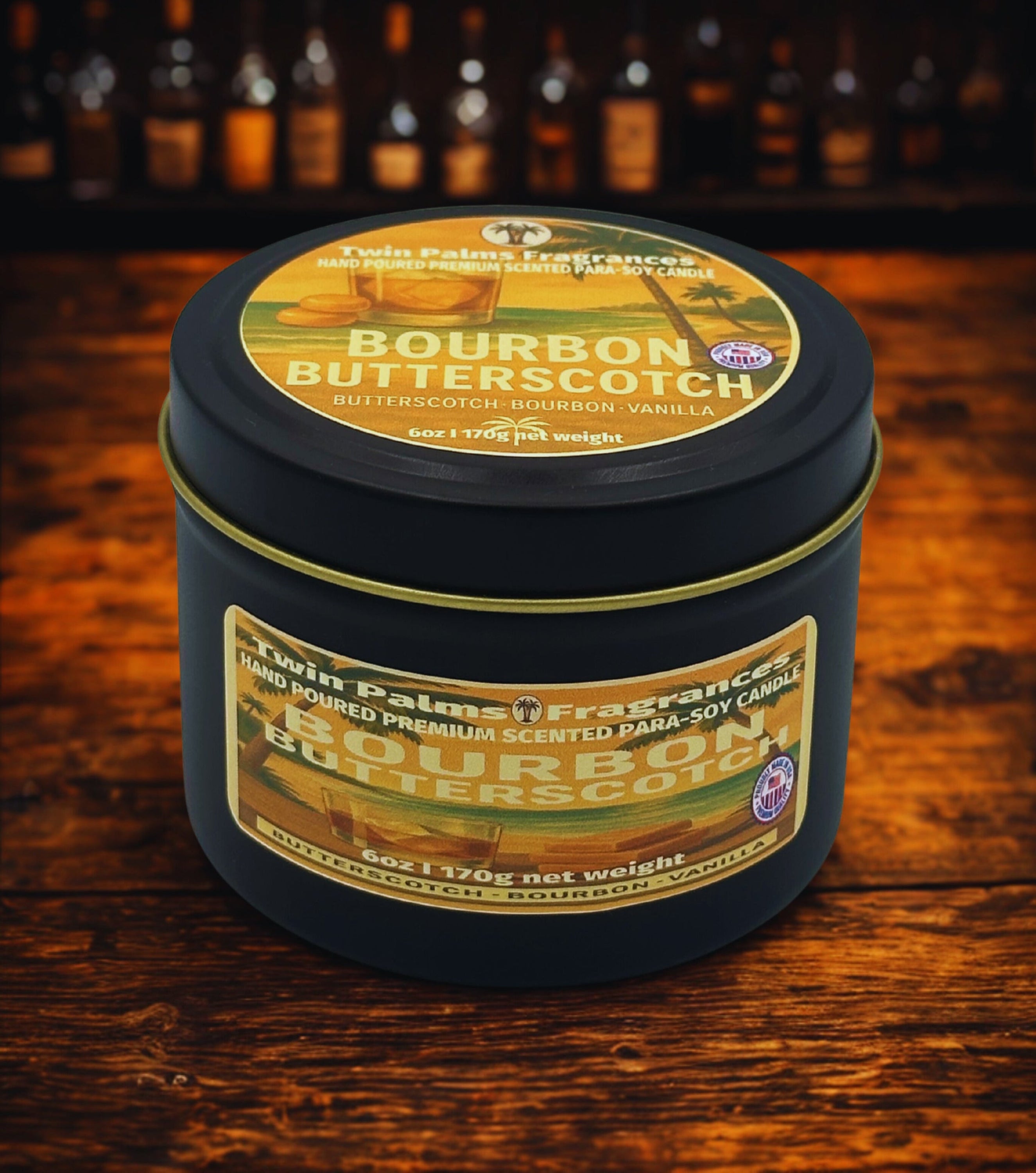 Twin Palms Fragrances Candle in a tin with 'Bourbon Butterscotch' label on a wooden surface