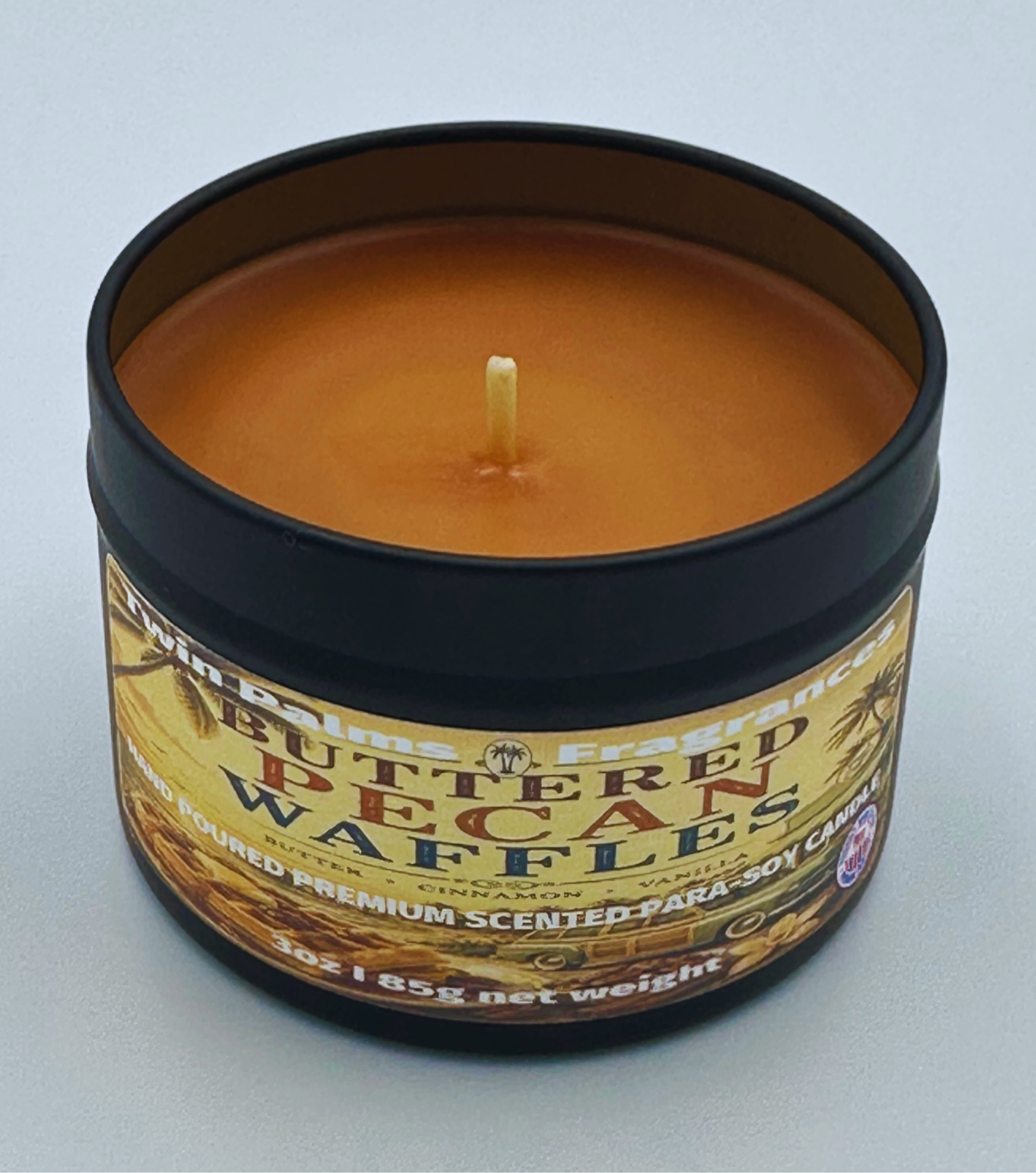 Twin Palms Fragrances Candle in a tin labeled 'Buttered Pecan Waffles' on a light gray background