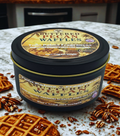 Container of 'Buttered Pecan Waffles' with waffles and pecans on a surface