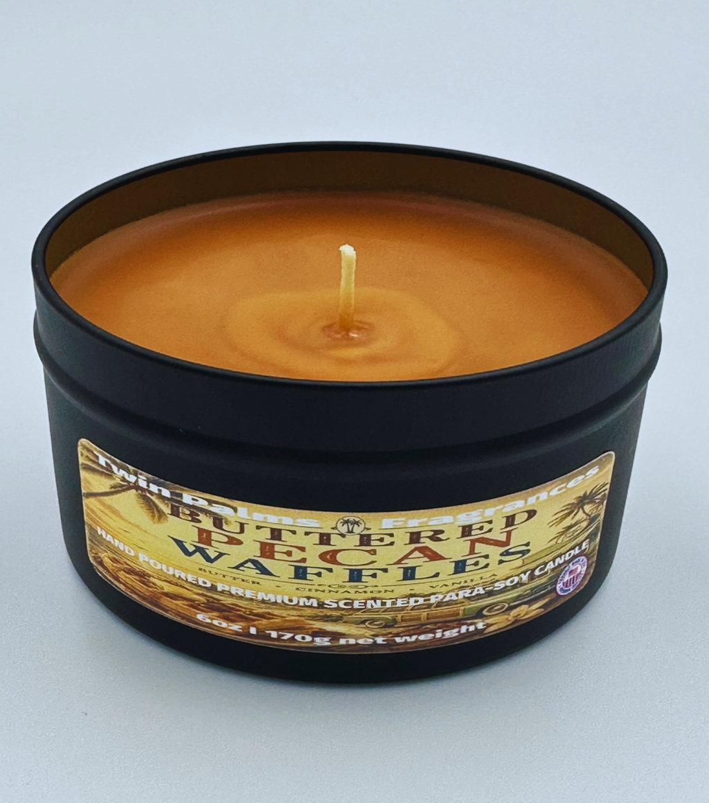 Candle in a tin labeled 'Buttered Pecan Waffles' on a light gray background