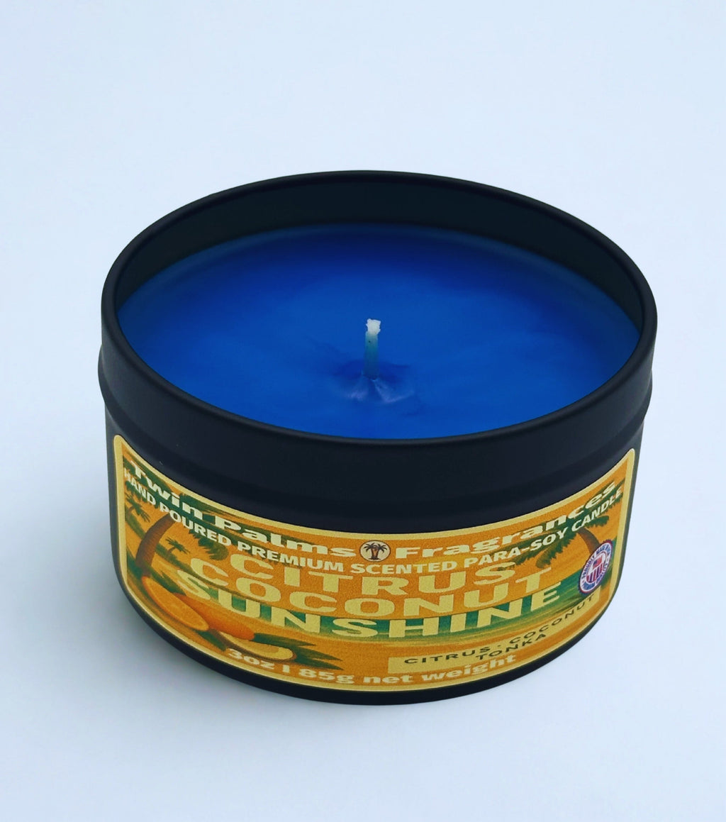 Twin Palms Fragrances Citrus Coconut Sunshine Candle in a tin with a colorful label on a light blue background