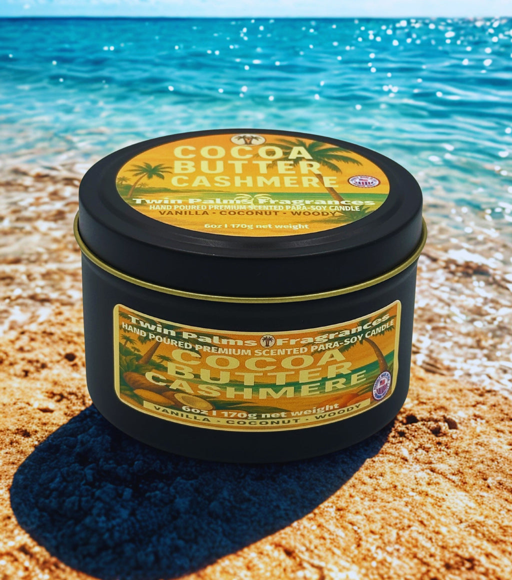 Twin Palms Fragrances Tin of Cocoa Butter Cashmere candle on a beach with ocean in the background