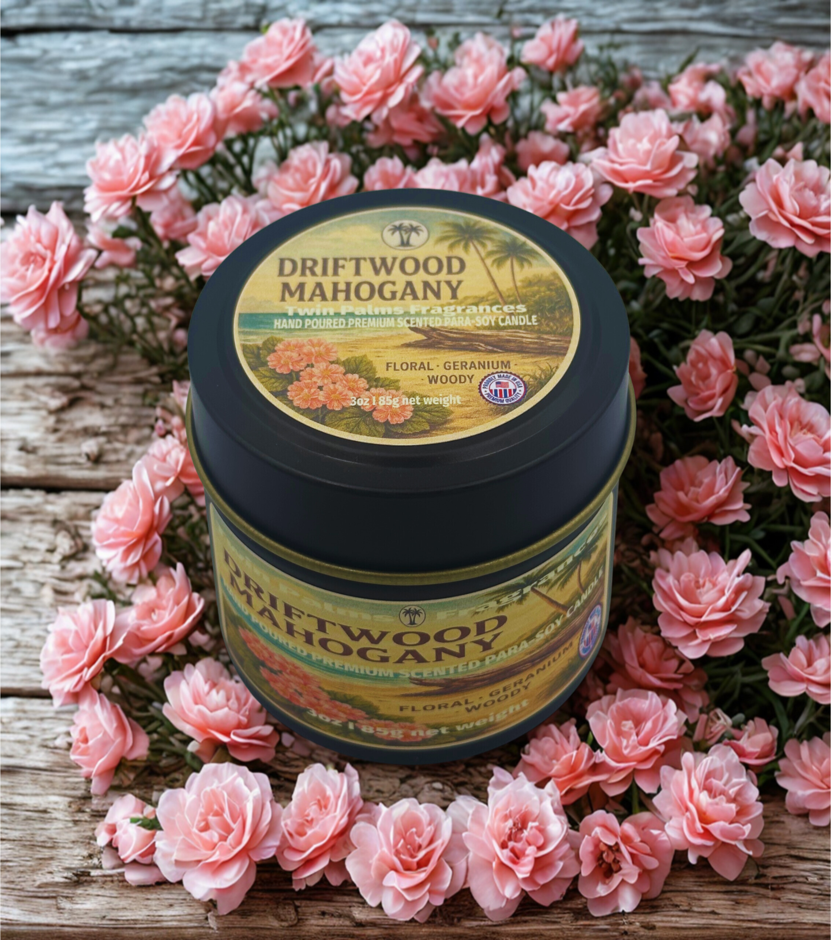Candle tin labeled 'Driftwood Mahogany' surrounded by pink flowers on a wooden surface