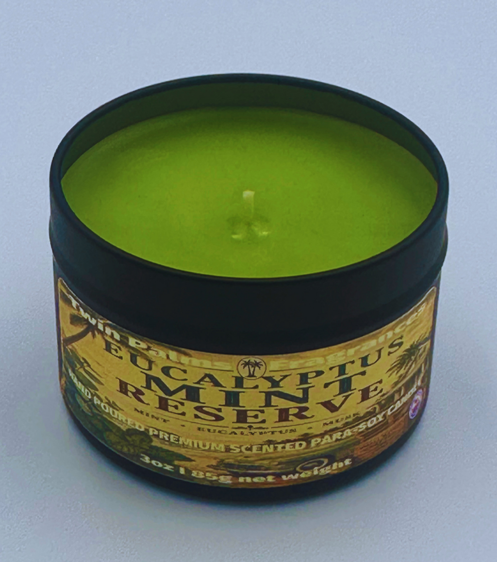 Twin Palms Fragrances green candle in a tin labeled 'Eucalyptus Mint Reserve' on a light gray background
