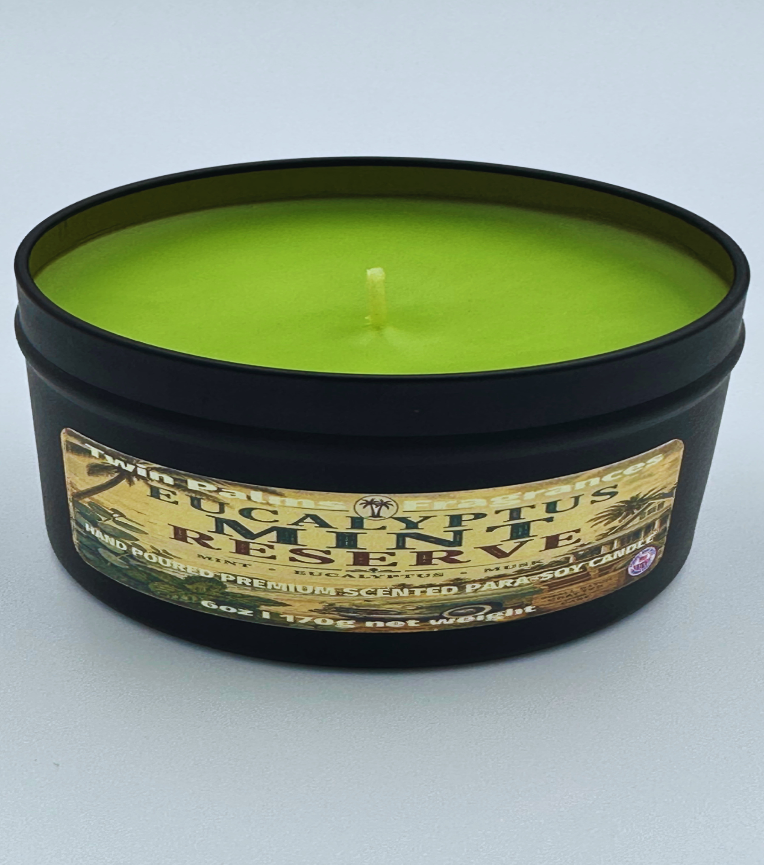 Twin Palms Fragrances Eucalyptus Mint Reserve green candle in a black container with a label on a white background