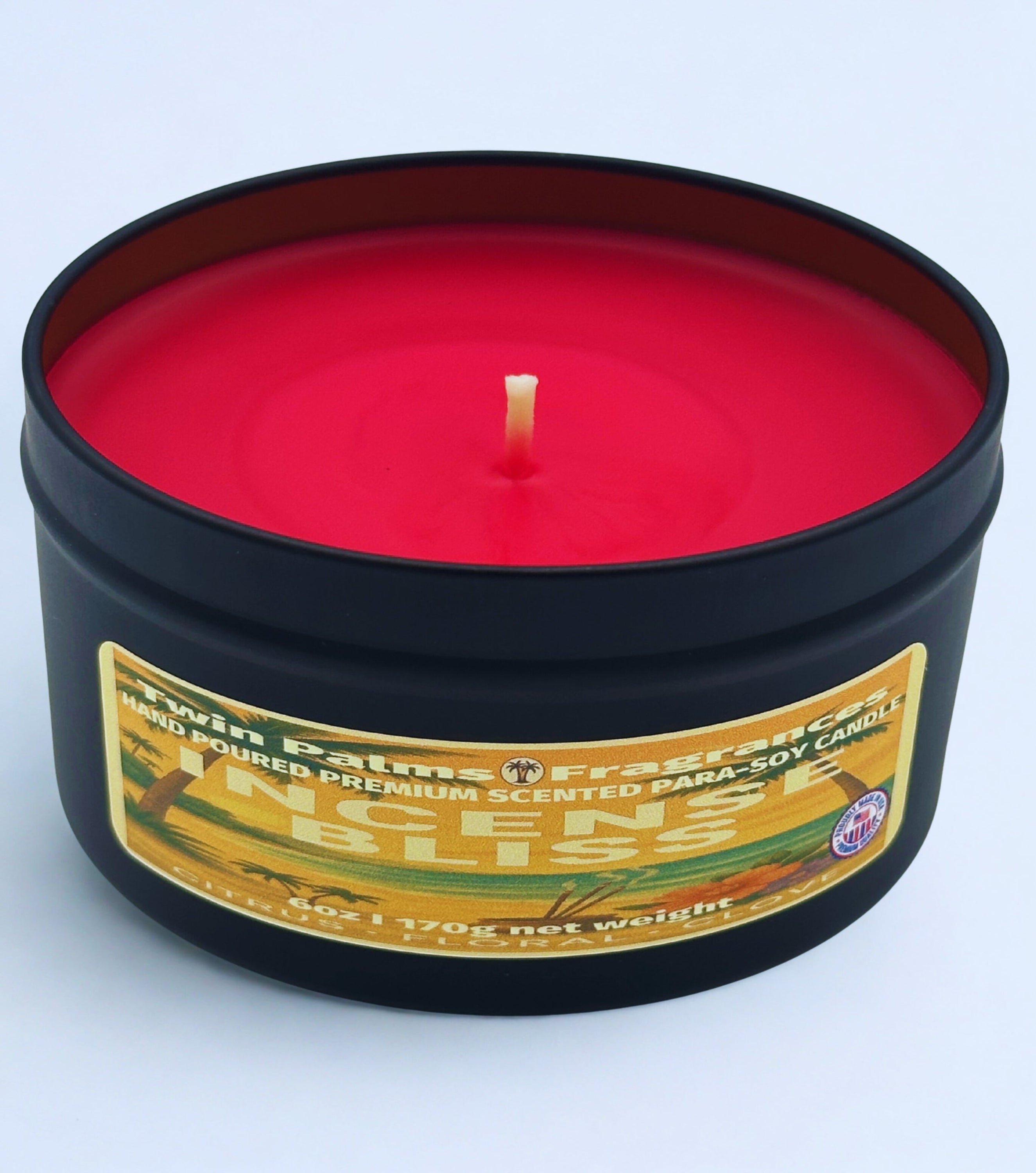 Incense Bliss red candle in a black tin with a label on a white background