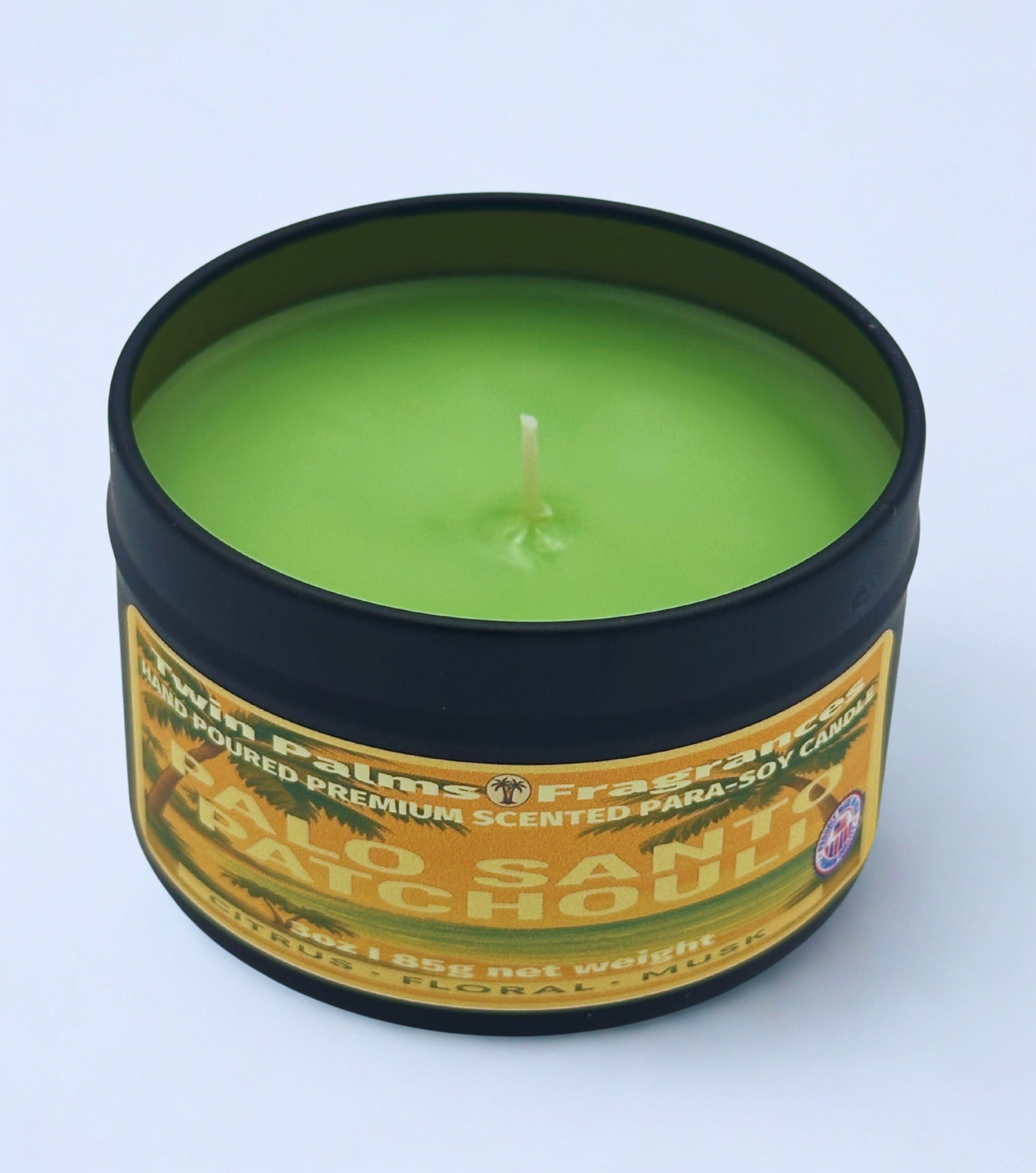 Twin Palms Fragrances green candle in a tin labeled 'Palo Santo Patchouli' on a white background