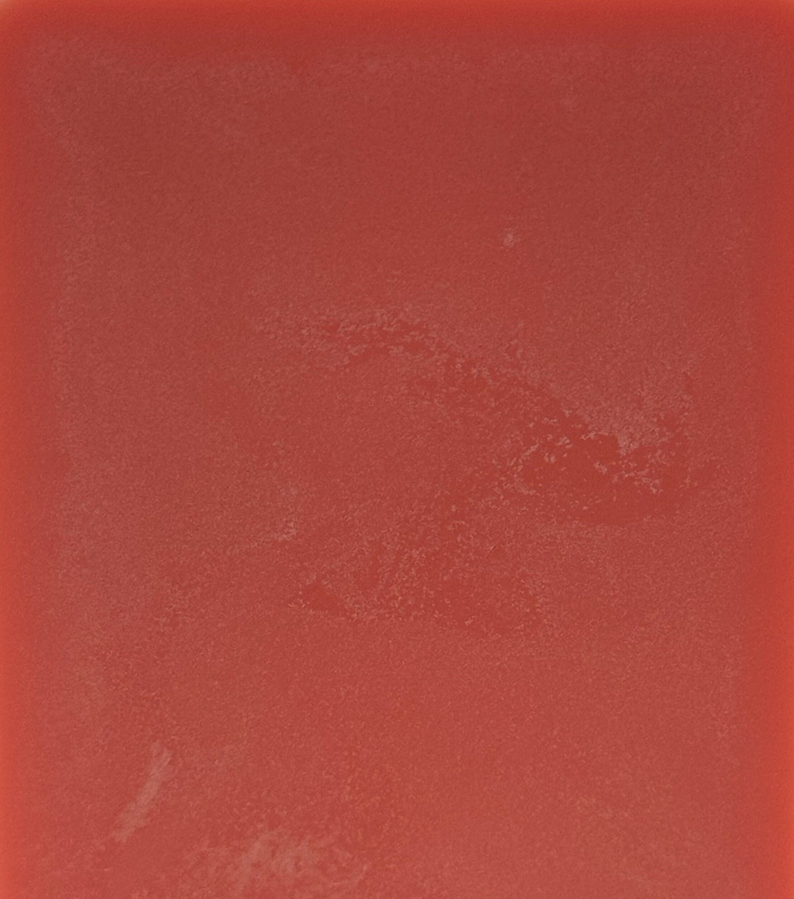 Solid red color swatch with a textured surface