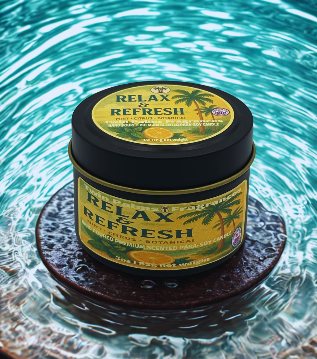 Tin of 'Relax & Refresh' candle on a reflective surface with water in the background