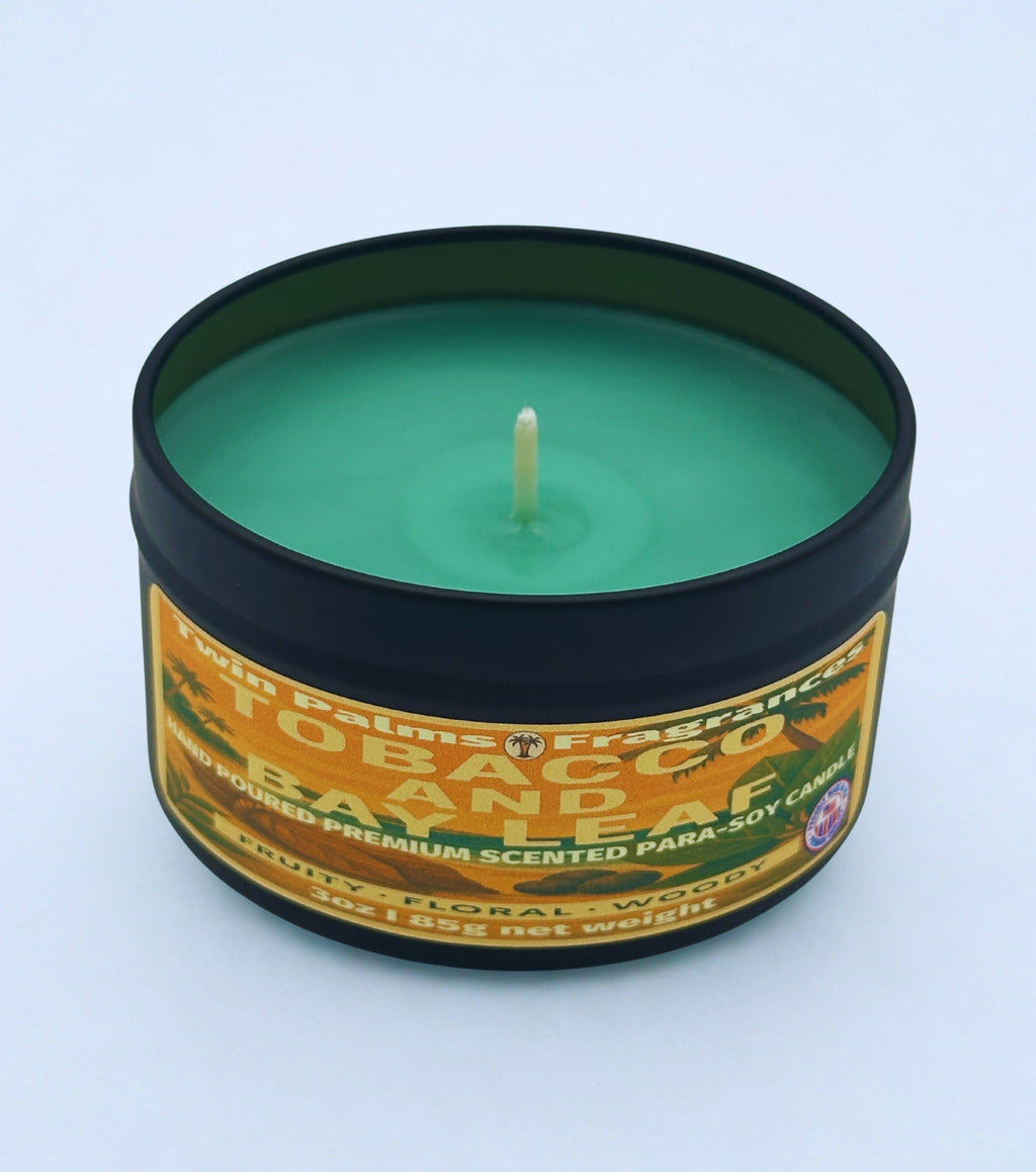 TOBACCO AND BAY LEAF Candle in a tin with a label on a light blue background
