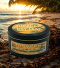 Twin Palms Tobacco and Bay Leaf candle tin on a beach with sunset
