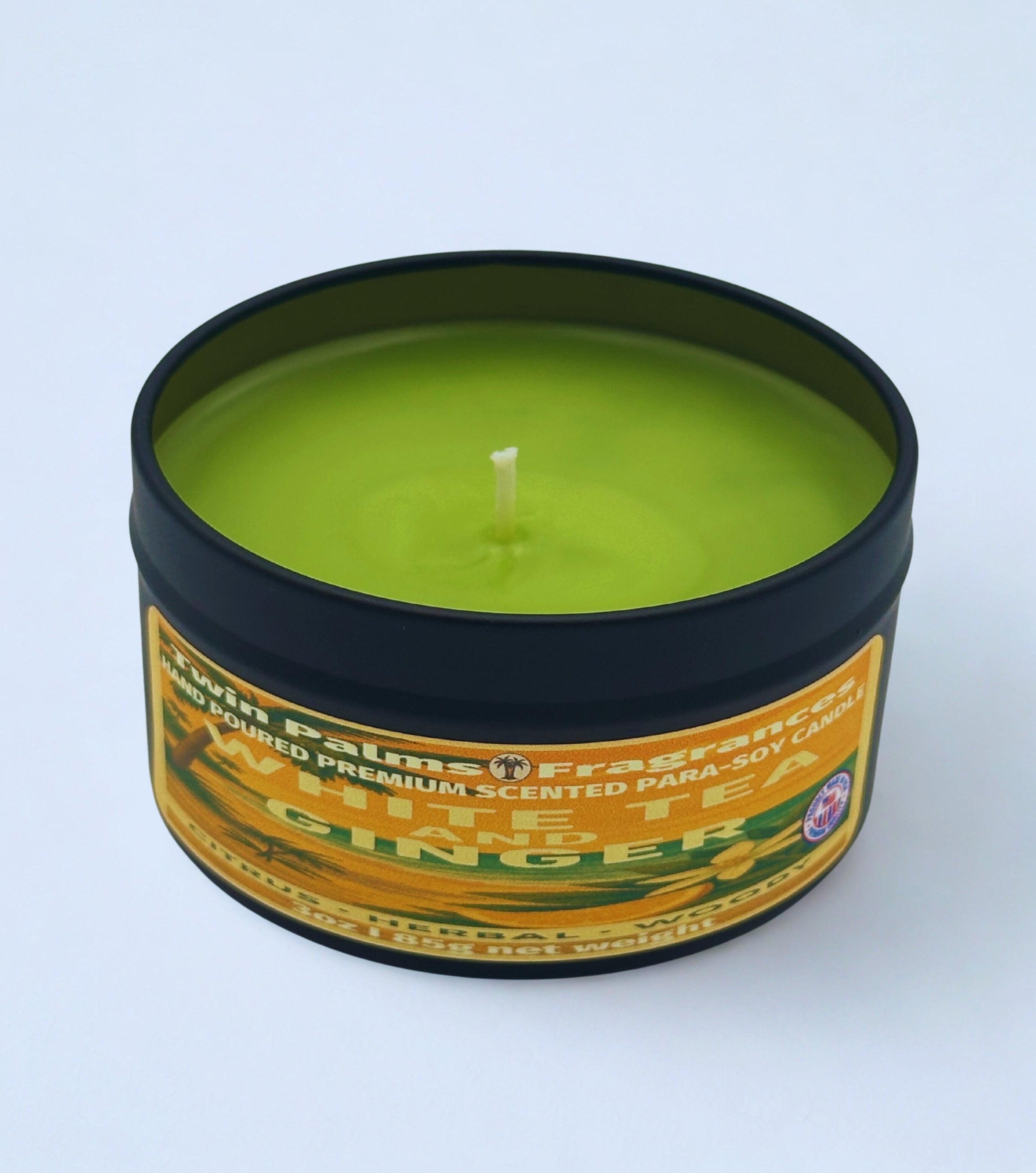 Candle in a tin labeled 'White Tea & Ginger' on a white background